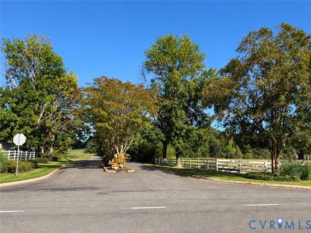 #30 Molly's Way, Urbanna, VA 23175 Paved cul-de-sac with manicured landscaping, white fence borders, and mature trees