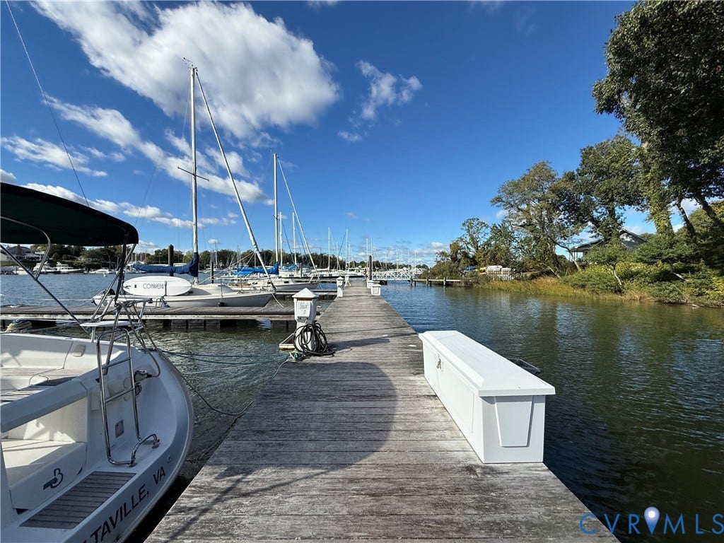 #30 Molly's Way, Urbanna, VA 23175 Wood-finish dock extending over water, with a boat secured to the dock, and additional boats moored in the background