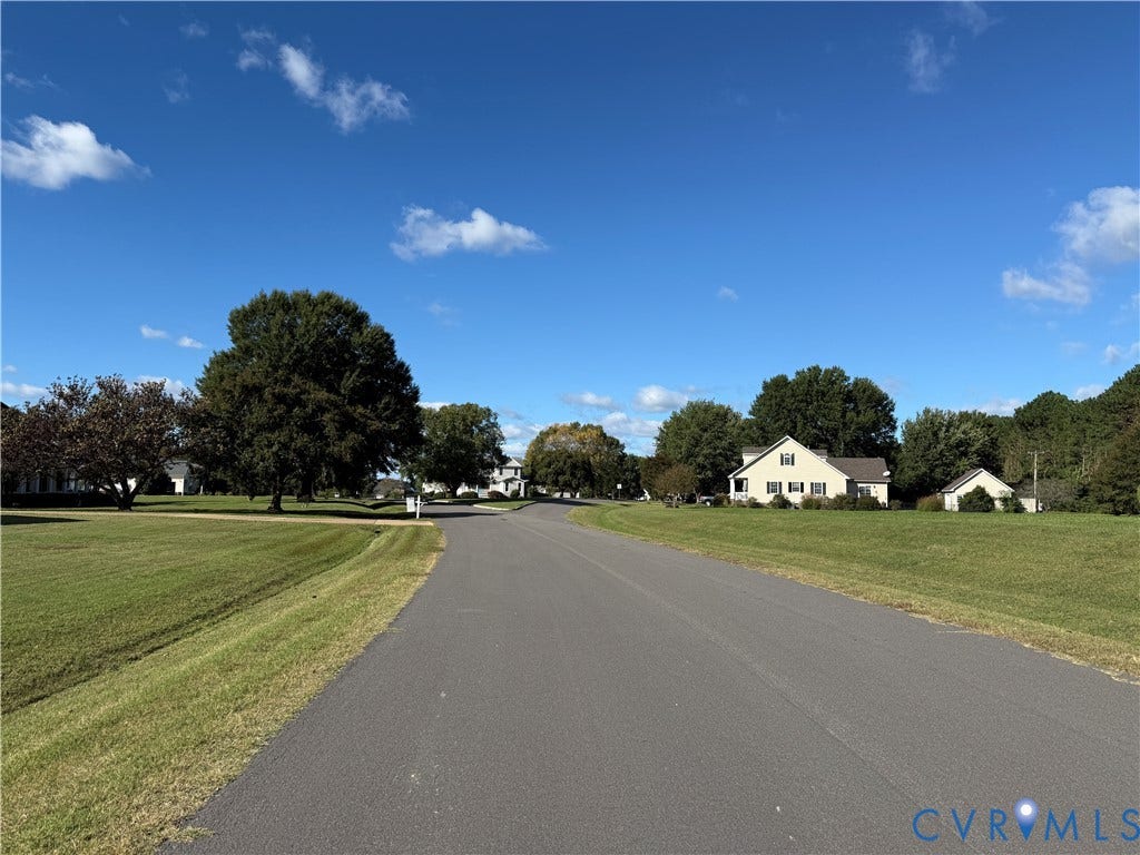 #30 Molly's Way, Urbanna, VA 23175 Paved roadway bordered by expansive grassy areas and mature trees