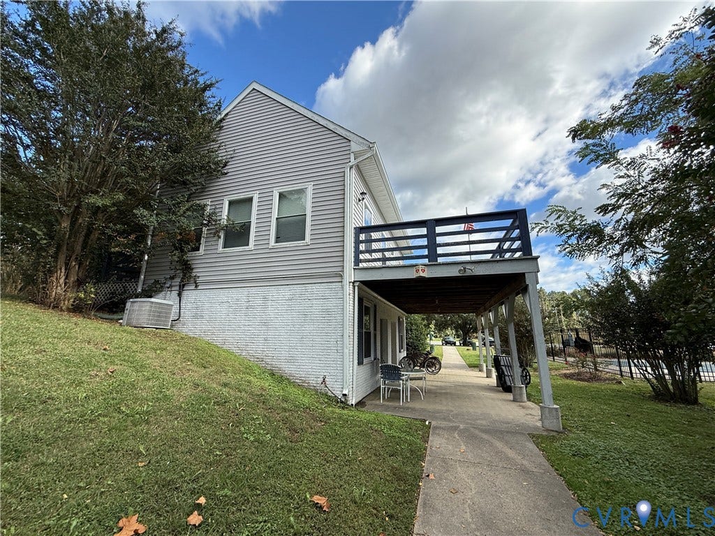 #30 Molly's Way, Urbanna, VA 23175 Upper-level deck with dark railing, lower-level covered patio, and a concrete pathway