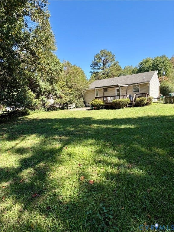Expansive lawn area with mature trees and a rear deck
