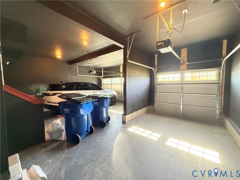 14225 Botsford Avenue, Wellspring, Chester, VA 23831 Multi-car garage featuring segmented overhead doors with paneled windows, high-contrast dark wall finish, and finished flooring
