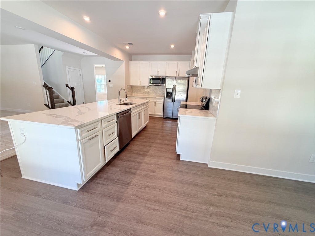14225 Botsford Avenue, Wellspring, Chester, VA 23831 Kitchen featuring white shaker-style cabinetry, a quartz waterfall island, stainless steel appliances, and wood-finish flooring
