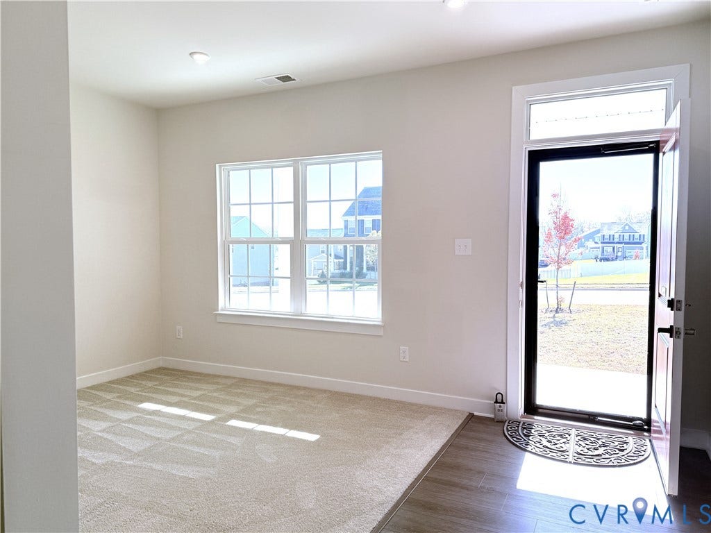 14225 Botsford Avenue, Wellspring, Chester, VA 23831 Neutral-toned wall-to-wall carpeting, wood-finish flooring, recessed lighting, double-hung windows with mullions, and a glass-panel entry door with a transom window