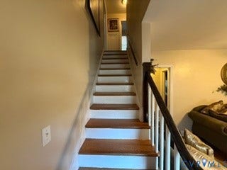 Hardwood stair treads with painted risers and a dark wood handrail