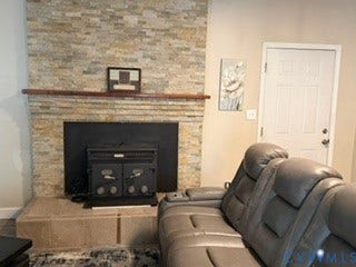Elegant living room featuring a custom stone fireplace with black surround and built-in gas insert, wood mantel, and neutral wall finishes