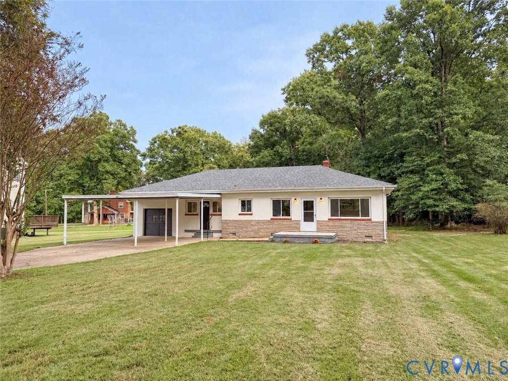 Single-story residence featuring a carport, attached garage, and a partial stone facade