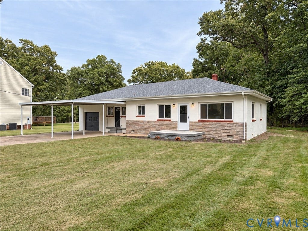 Single-story exterior with a carport, stone veneer detailing, and a shingled roof