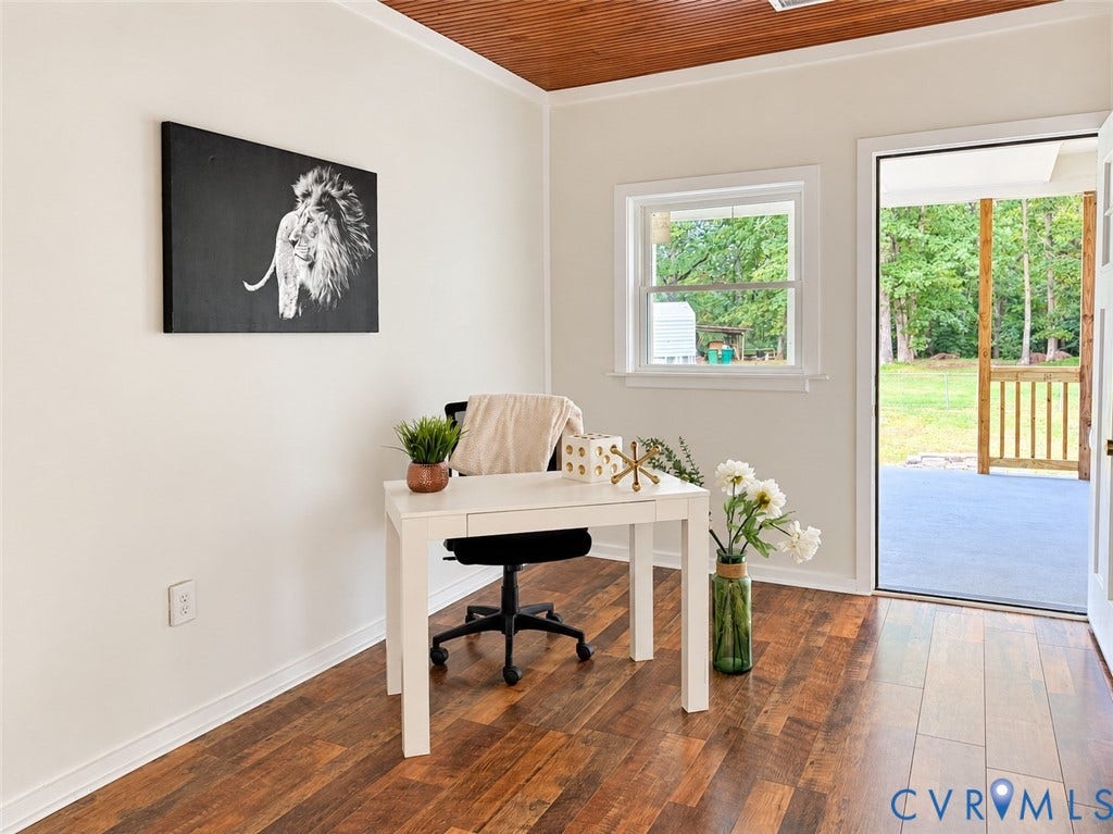 Wood-finish flooring, white walls, wood-paneled ceiling, single window, and a glass-paneled door