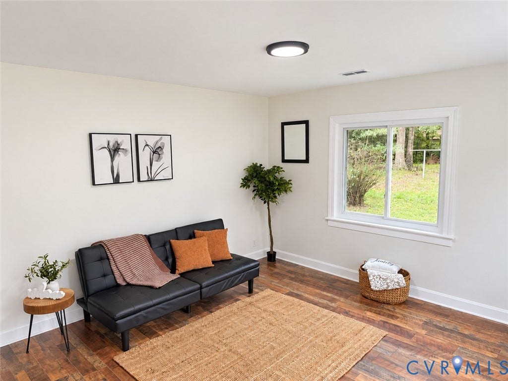 Wood-finish flooring, white walls, and a large window with white trim