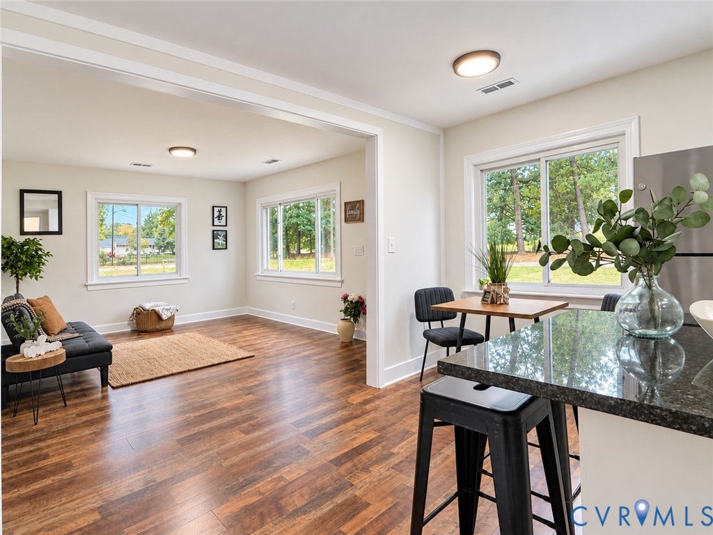 Open-concept living space with wood-finish flooring, white trim, and recessed lighting