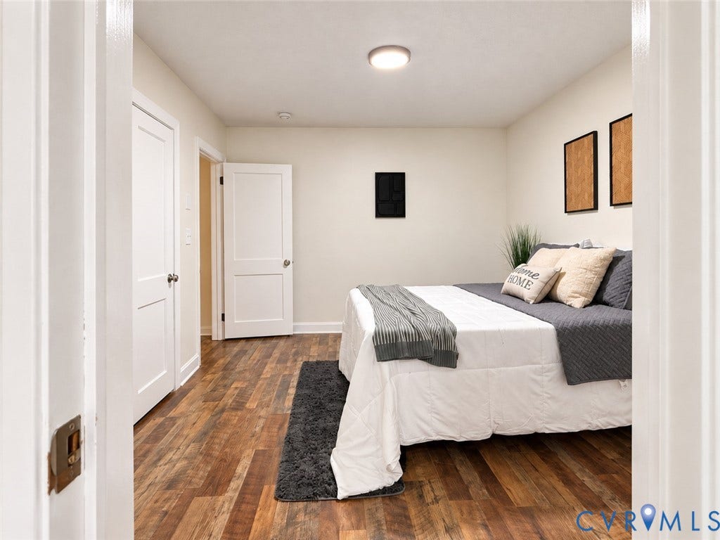 Wood-finish flooring throughout, bright white walls, and a recessed ceiling light