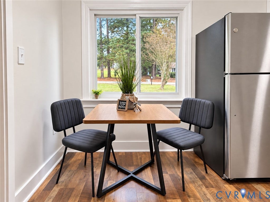 Wood-finish flooring, white trim, and a double-pane window