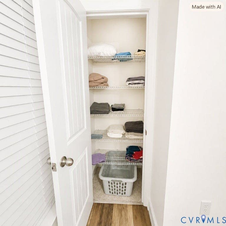 6722 Gibe Lane, Chesterfield, VA 23234 2nd Bedroom extra closet featuring five tiers of white wire shelving, a classic multi-panel interior door with a brushed metallic knob, and wood-finish flooring. This image has been digitally enhanced using AI for presentation, lighting and clarity.