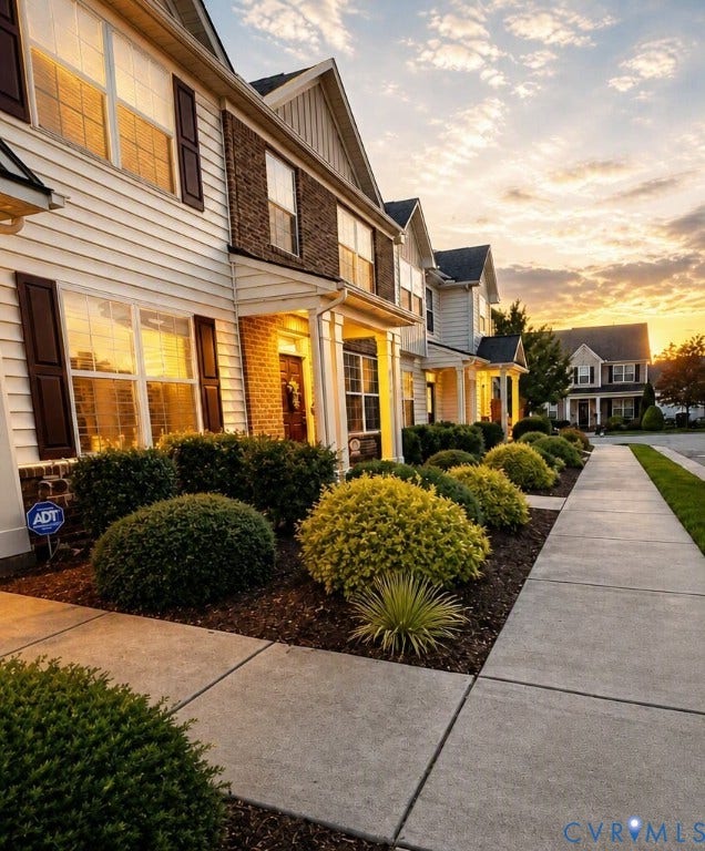 6722 Gibe Lane, Chesterfield, VA 23234 Multi-story exterior featuring a mix of horizontal lap siding and brick facade, decorative window shutters, a covered front entryway, and landscaped garden beds. This image has been digitally enhanced using AI for lighting and clarity.