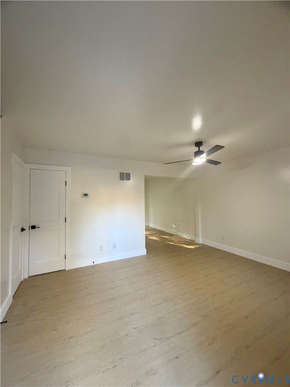 Wood-finish flooring throughout, modern ceiling fan with integrated lighting, and white interior doors with matte black hardware