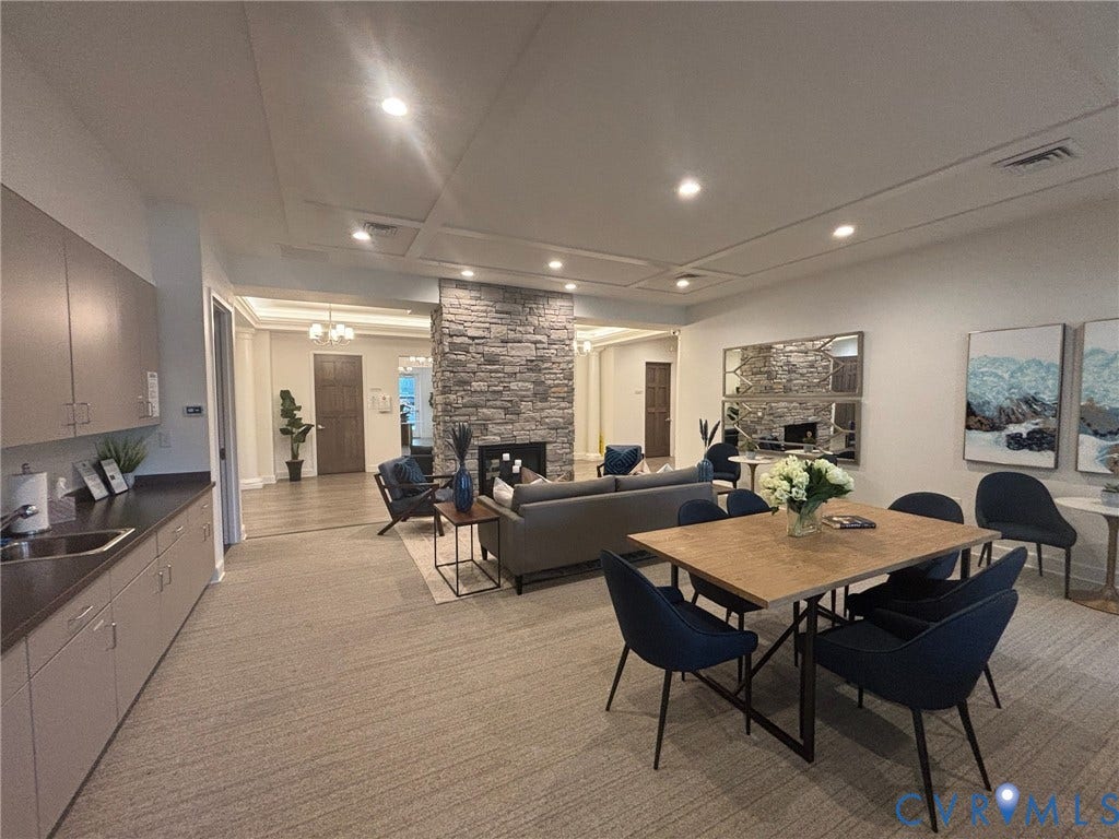 7580 Southamptonshire Way, Autumn Pines, New Kent, VA 23124 Spacious common area featuring a stone fireplace, recessed lighting, wood-finish flooring, and a built-in cabinetry with sink