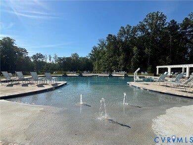 7580 Southamptonshire Way, Autumn Pines, New Kent, VA 23124 Expansive swimming pool with a shallow entry area, three water features, and a surrounding paved deck