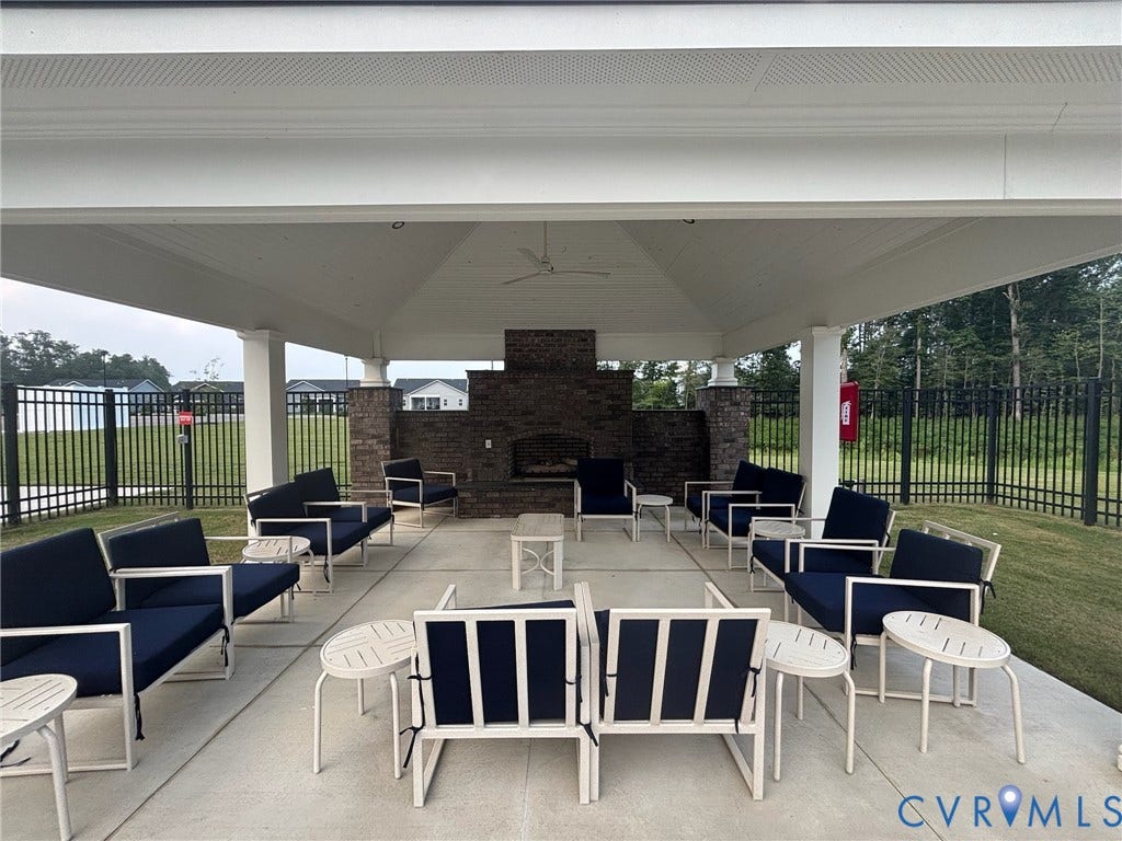 7580 Southamptonshire Way, Autumn Pines, New Kent, VA 23124 Covered outdoor patio with a brick-clad fireplace, ceiling fan, and recessed lighting