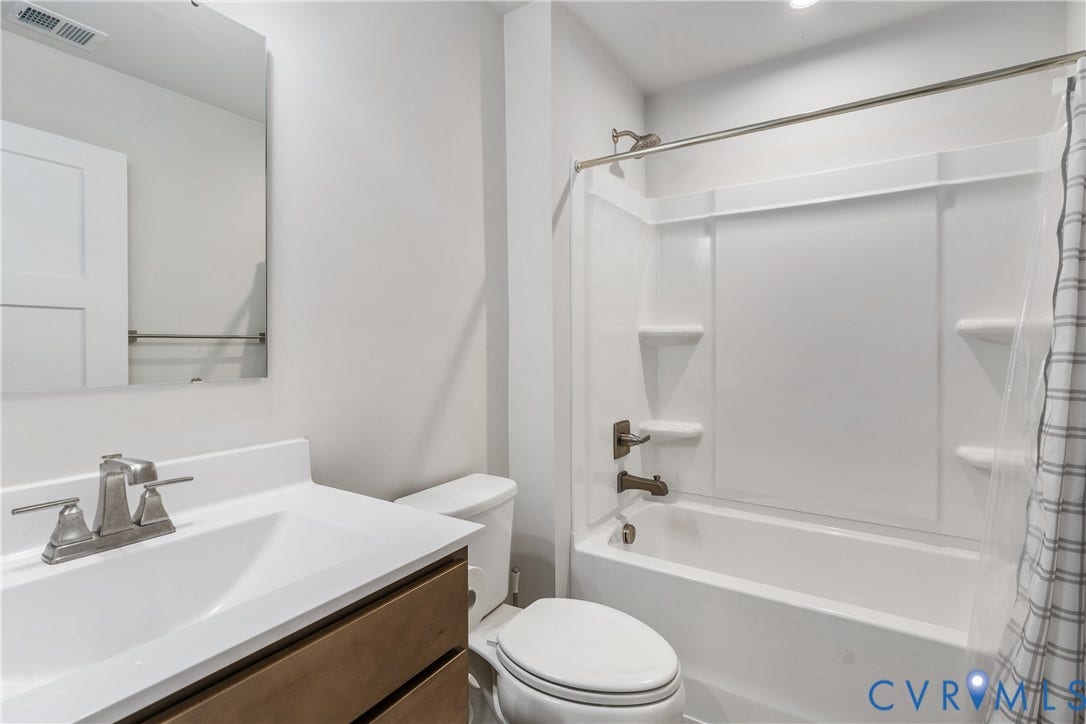 7580 Southamptonshire Way, Autumn Pines, New Kent, VA 23124 Bathroom with wood-finish vanity, integrated sink, brushed nickel faucet, and a white bathtub with a shower kit