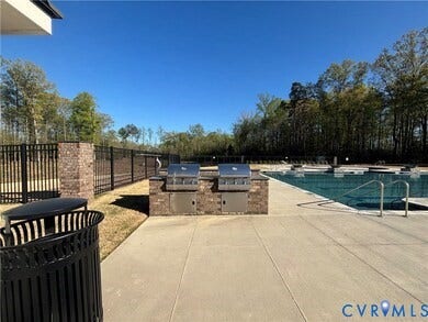 7580 Southamptonshire Way, Autumn Pines, New Kent, VA 23124 Expansive swimming pool with integrated tanning ledges, surrounded by a concrete deck