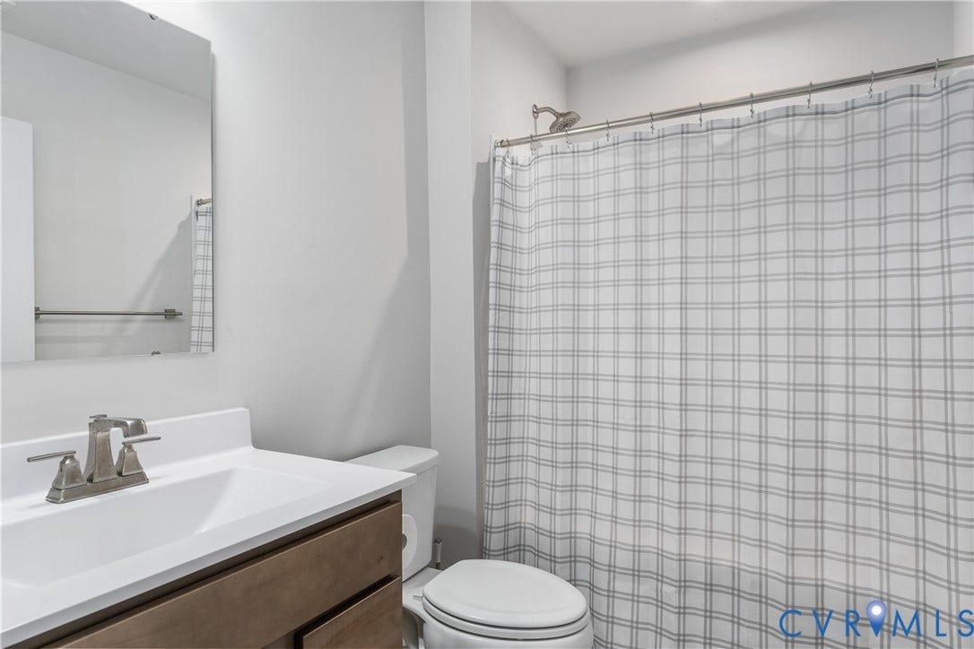 7580 Southamptonshire Way, Autumn Pines, New Kent, VA 23124 Bathroom featuring a shower with a chrome shower head, a single vanity with a white countertop, and a mirror