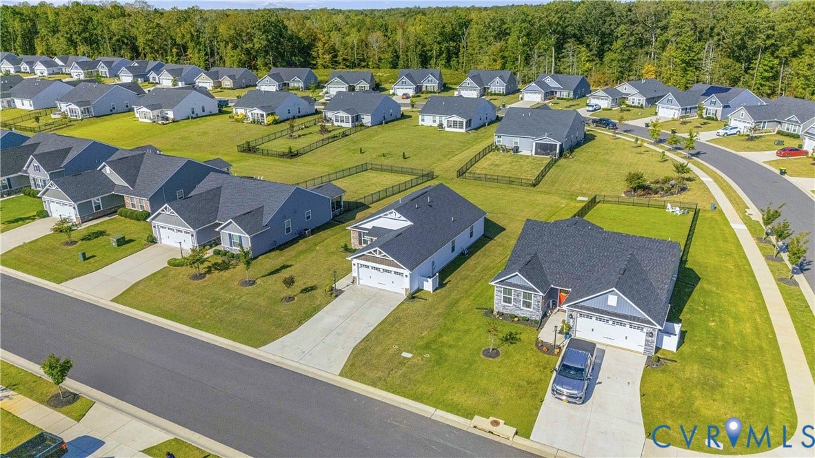 7580 Southamptonshire Way, Autumn Pines, New Kent, VA 23124 Grassy yards, a tree line backdrop, and uniform residential architecture
