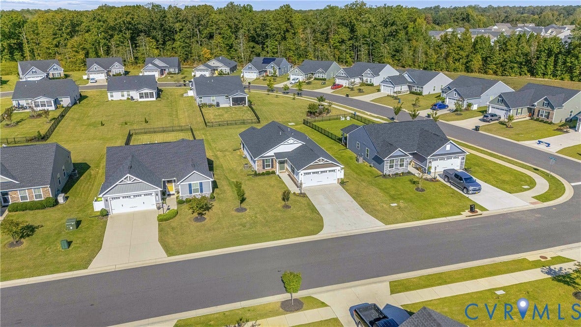 7580 Southamptonshire Way, Autumn Pines, New Kent, VA 23124 Contemporary neighborhood setting with paved streets and sidewalks, featuring landscaped front yards and a tree line backdrop