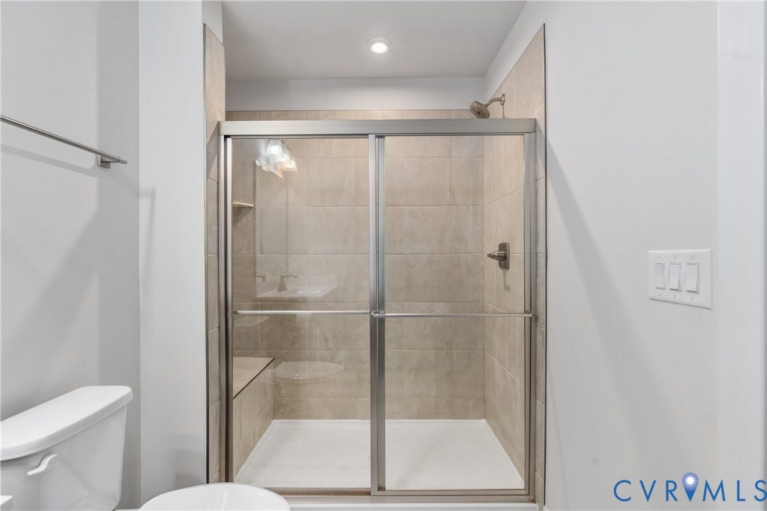 7580 Southamptonshire Way, Autumn Pines, New Kent, VA 23124 Tiled shower enclosure with sliding glass door, built-in bench, and recessed lighting