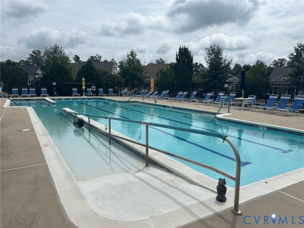7580 Southamptonshire Way, Autumn Pines, New Kent, VA 23124 Expansive community swimming pool with lap lanes, accessible entry ramp, surrounding lounge chairs, and perimeter fencing