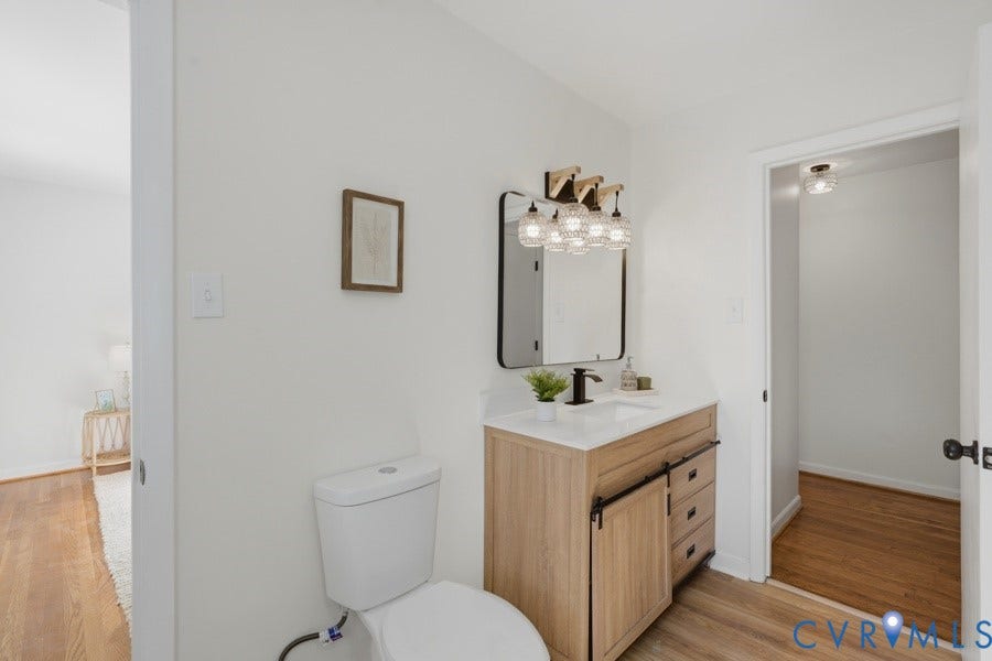20306 Sheffield Place, Laurel Branch Farms, South Chesterfield, VA 23803 Bathroom featuring a single vanity with wood-finish cabinetry, a white countertop, and a black framed mirror