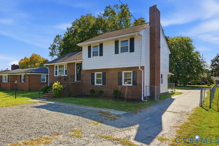 20306 Sheffield Place, Laurel Branch Farms, South Chesterfield, VA 23803 Split-level residence featuring brick and siding exterior, a prominent brick chimney, and a gravel driveway