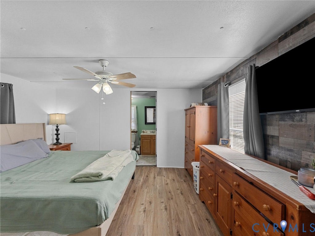 17009 Lansmill Drive, South Chesterfield, VA 23834 Wood-finish flooring, ceiling fan with light fixture, and accent wall with horizontal paneling