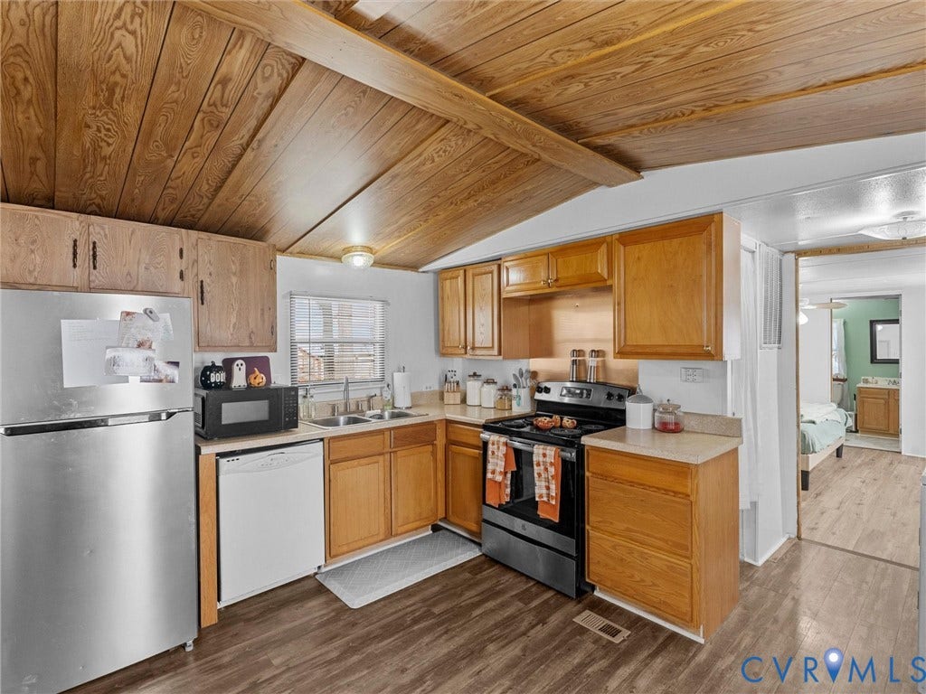 17009 Lansmill Drive, South Chesterfield, VA 23834 Kitchen featuring wood-finish flooring, wood cabinetry, a stainless steel refrigerator, a double basin sink, and a four-burner electric range