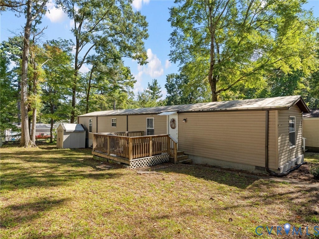 17009 Lansmill Drive, South Chesterfield, VA 23834 Exterior siding, elevated wooden deck, outdoor storage shed, and mature trees