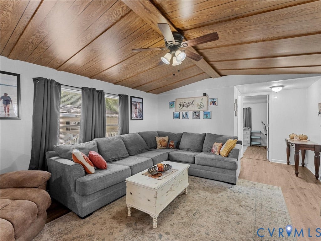 17009 Lansmill Drive, South Chesterfield, VA 23834 Vaulted wood-finish ceiling, exposed wood beams, ceiling fan light fixture, multiple windows, and wood-finish flooring