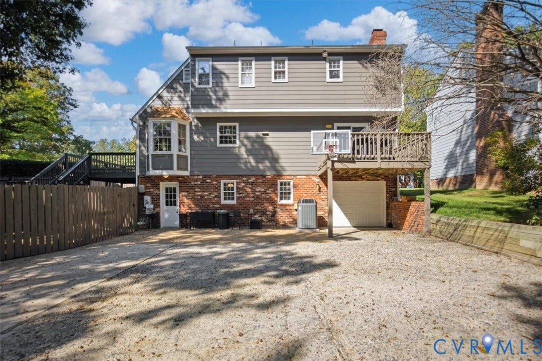863 Watch Hill Road, Midlothian, VA 23114 Multi-level exterior featuring gray siding, a brick foundation, a bay window, an upper-level deck, and a garage with an automatic door