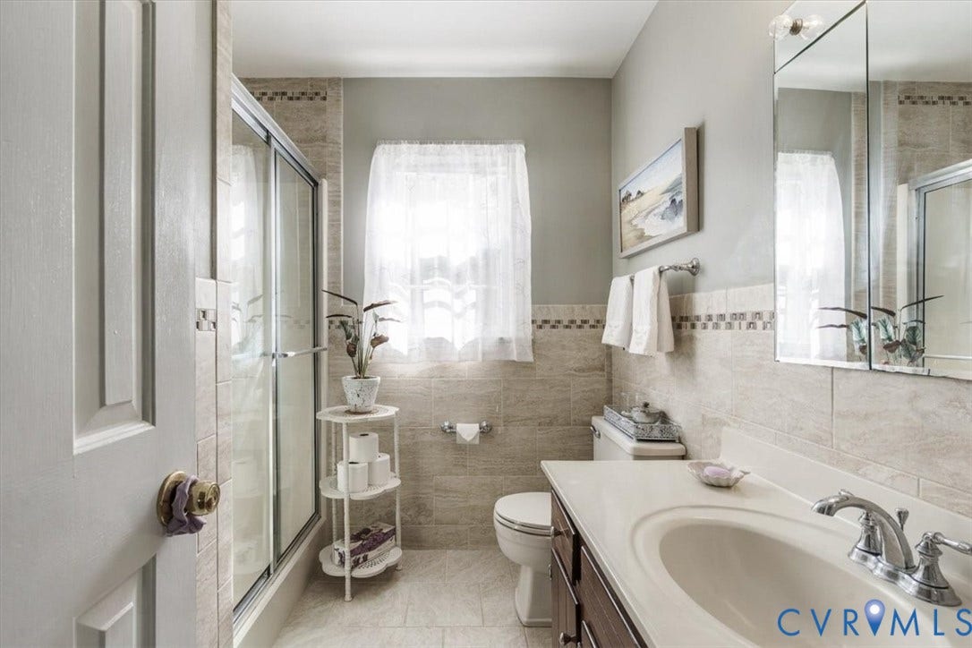 863 Watch Hill Road, Midlothian, VA 23114 Spa-inspired primary bathroom featuring a walk-in shower with glass enclosure and tile surround, dual vanity with undermount sinks and chrome fixtures, porcelain tile flooring, and abundant natural light from a large window