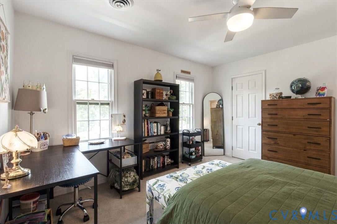 863 Watch Hill Road, Midlothian, VA 23114 Bright, multi-functional bedroom featuring hardwood-finish flooring, substantial wood dresser with multiple drawers, built-in shelving unit with storage cubbies, large double-hung windows with natural light, and ceiling fan with integrated lighting