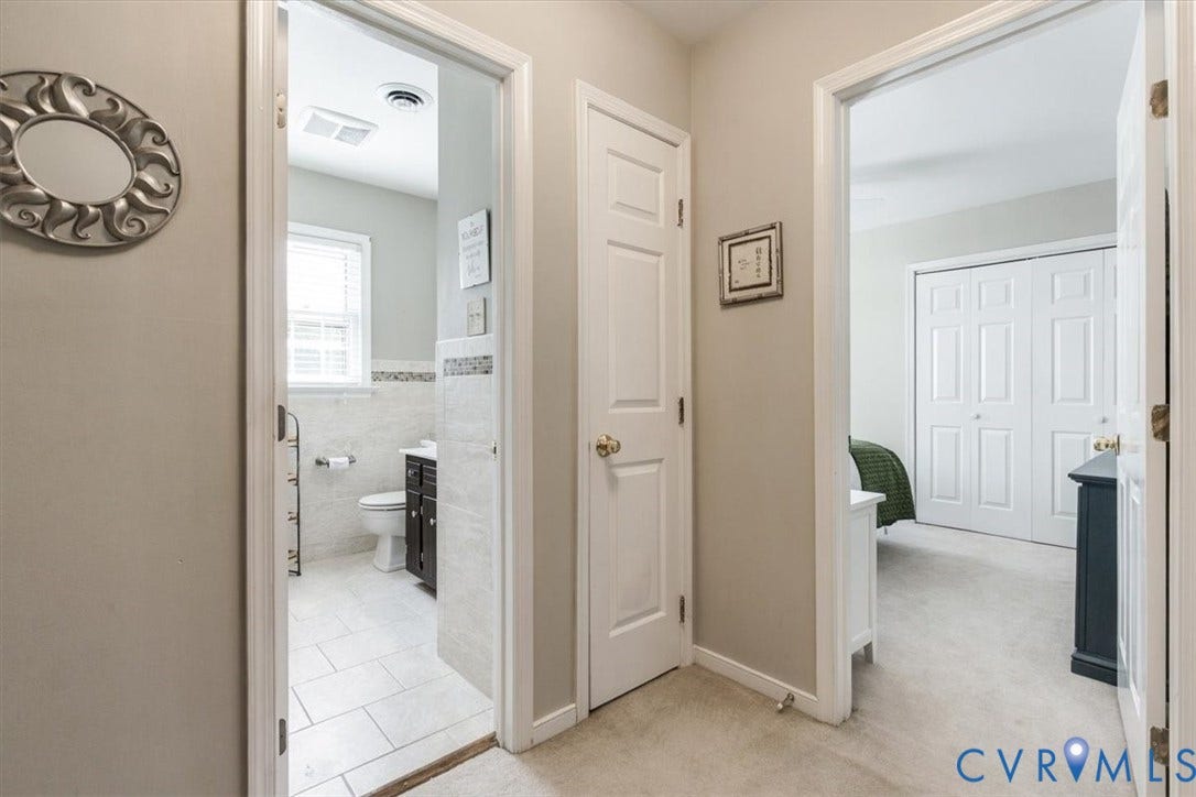 863 Watch Hill Road, Midlothian, VA 23114 Hallway featuring neutral wall finishes, ceramic tile flooring, multiple white six-panel doors with brass hardware, and a decorative wall-mounted circular accent piece