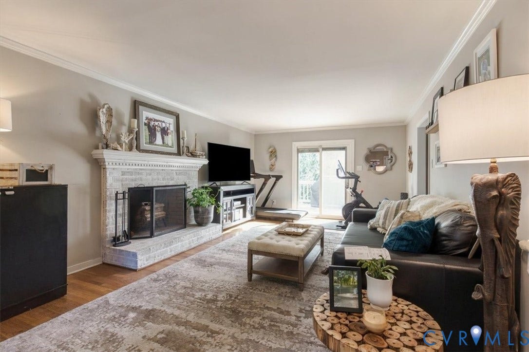 863 Watch Hill Road, Midlothian, VA 23114 Bright and spacious living room featuring hardwood flooring, a wood-burning fireplace with tile surround and mantel display space, built-in media cabinetry, and large windows with natural light