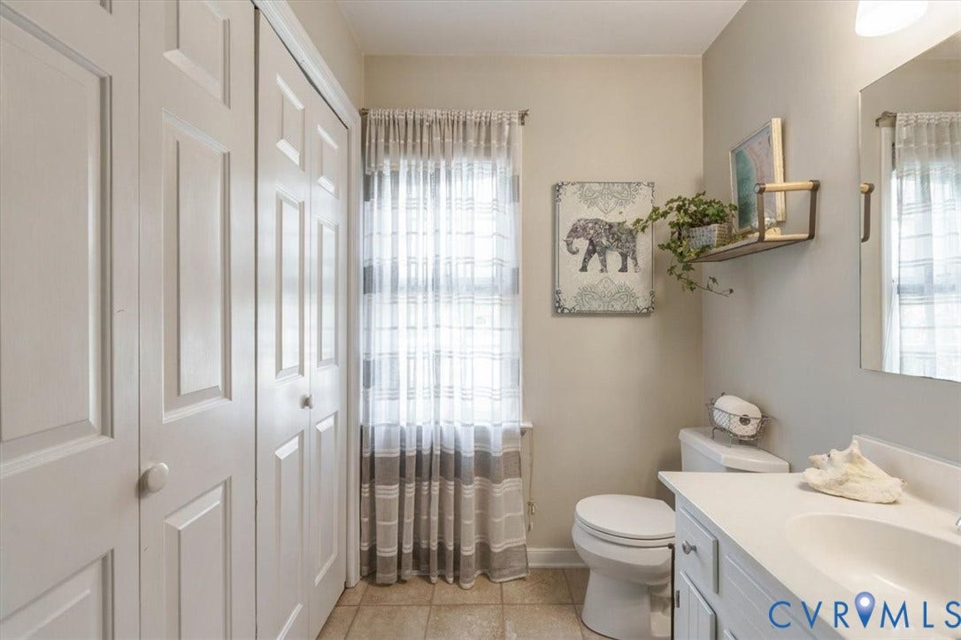 863 Watch Hill Road, Midlothian, VA 23114 Bright secondary bathroom featuring a vanity with ample countertop space, ceramic tile flooring, toilet, and a shower/tub combination enclosed by a striped curtain