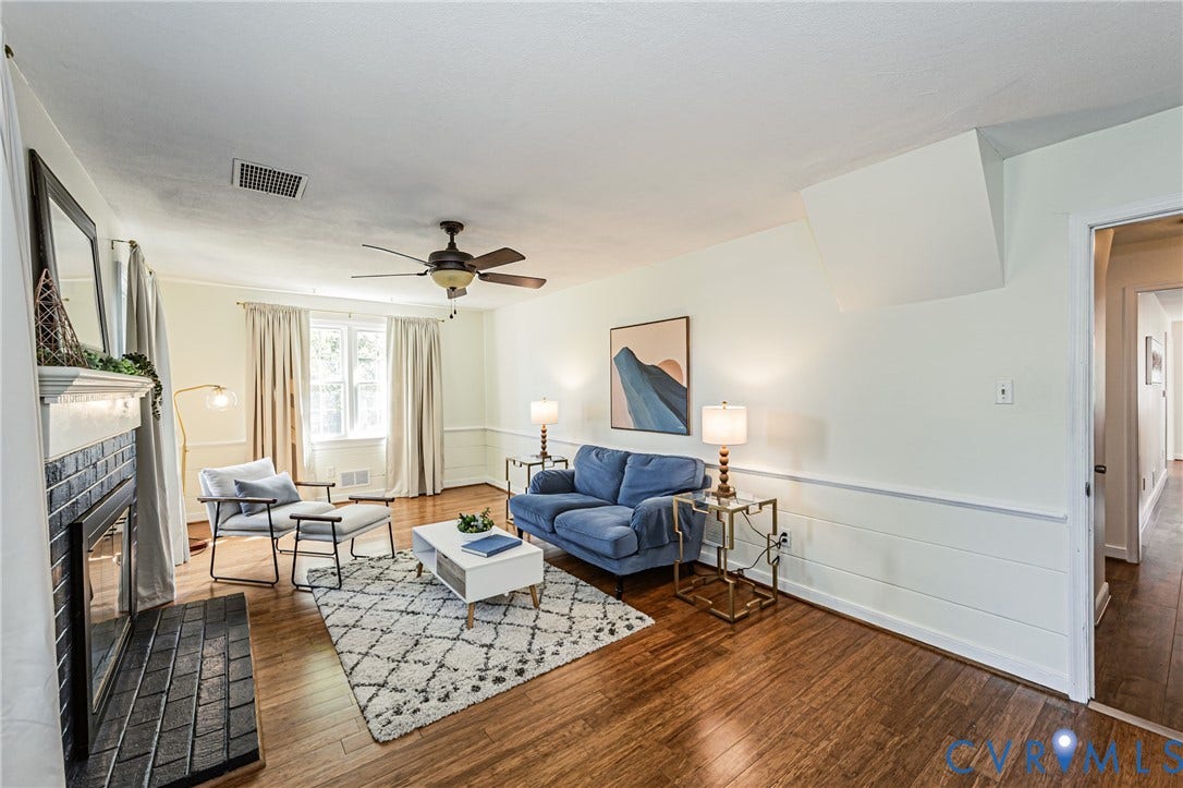 1608 Lochwood Drive, Henrico, VA 23238 Wood-finish flooring, white paneled wainscoting, ceiling fan, and a fireplace with a black tile surround