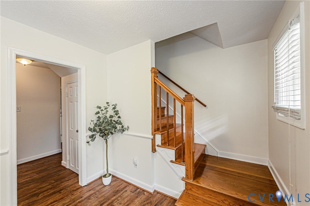 1608 Lochwood Drive, Henrico, VA 23238 Hardwood staircase with natural wood railing, wood-finish flooring, and a window with blinds