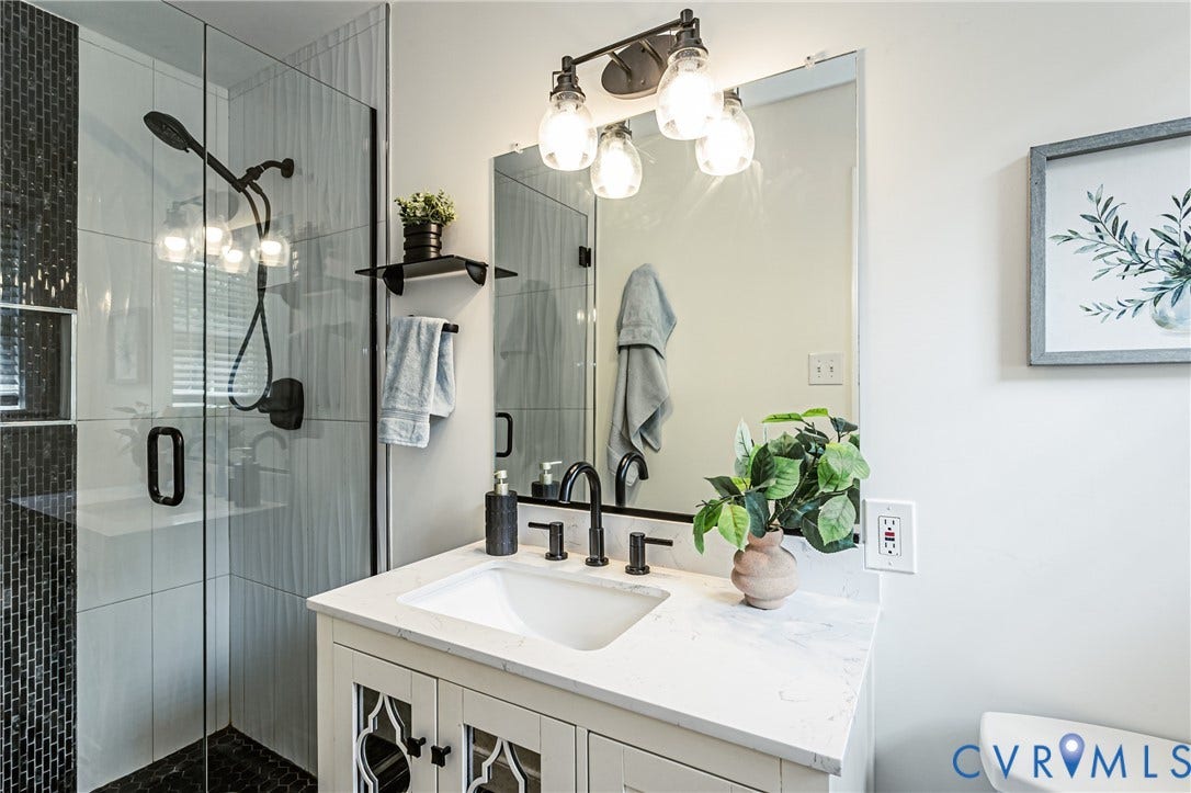 1608 Lochwood Drive, Henrico, VA 23238 White vanity with patterned cabinet doors and a white countertop, featuring a rectangular undermount sink with a matte black faucet