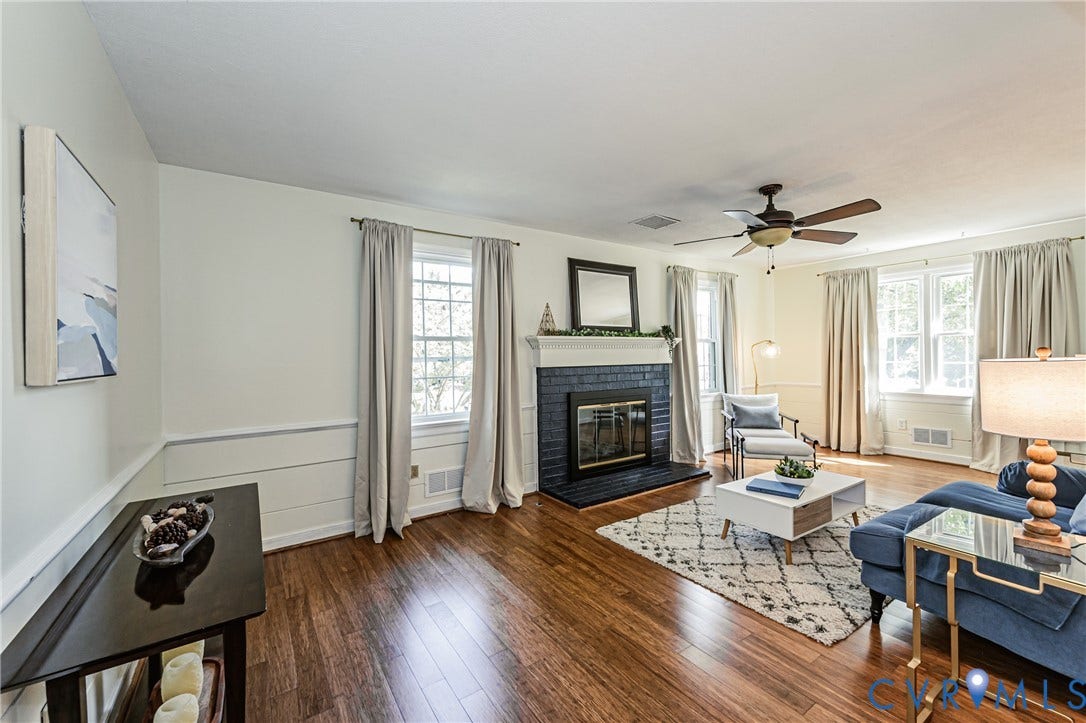1608 Lochwood Drive, Henrico, VA 23238 Wood-finish flooring throughout, a fireplace with a black tile surround, a built-in ceiling fan, and multiple windows with trim