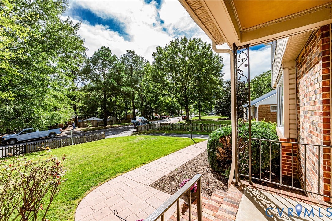 1608 Lochwood Drive, Henrico, VA 23238 Expansive backyard oasis featuring a manicured lawn, mature shade trees, and a brick paver patio