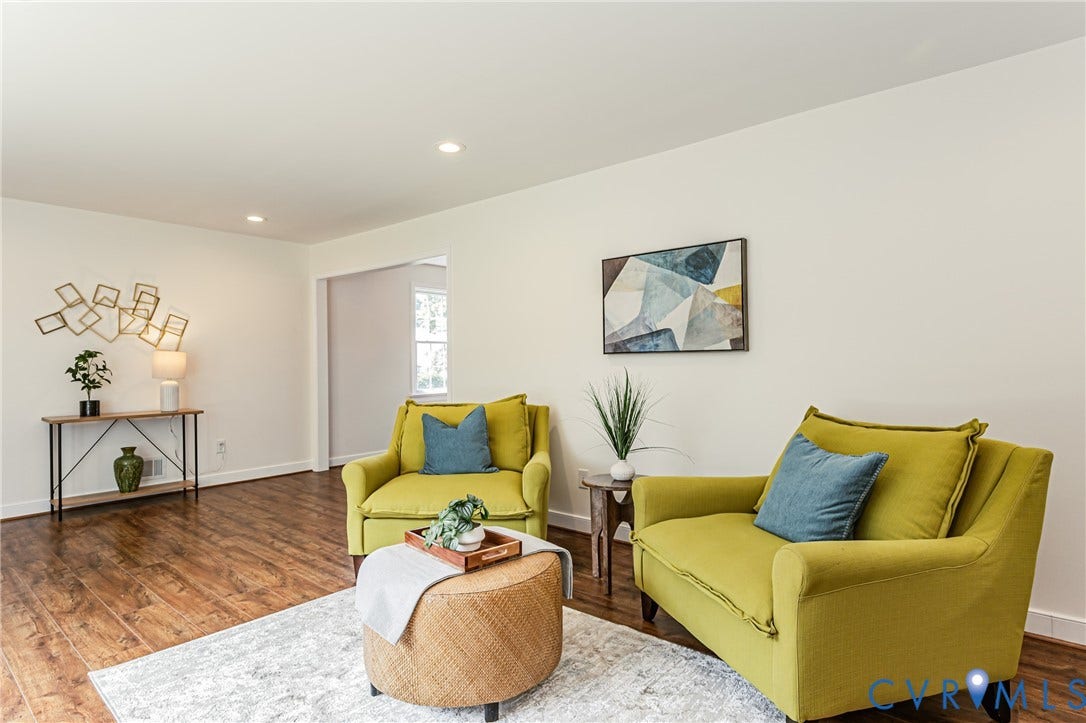 1608 Lochwood Drive, Henrico, VA 23238 Bright living room showcasing warm wood-finish flooring, recessed ceiling lighting, and generous natural light from multiple windows