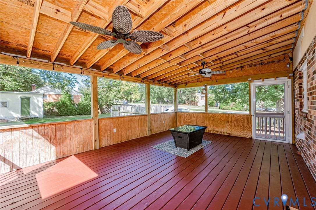 1608 Lochwood Drive, Henrico, VA 23238 Expansive screened porch with a stained wood floor, exposed wood beam ceiling, and two ceiling fans