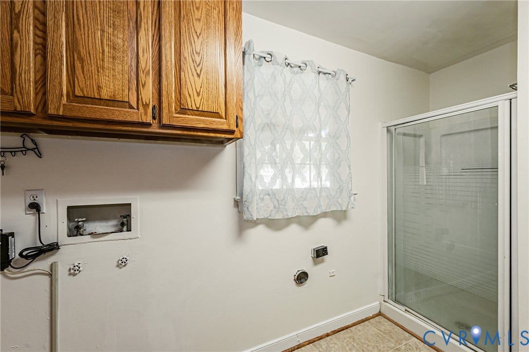 1608 Lochwood Drive, Henrico, VA 23238 Primary bathroom featuring ceramic tile flooring, wood-finish cabinetry with organized storage, frameless glass shower enclosure with tile surround, and chrome fixtures throughout